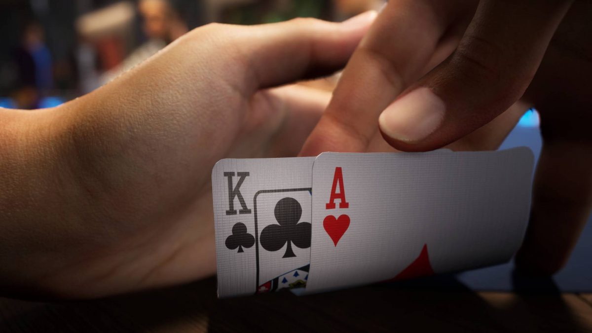 Close up detail of a players hands revealing a king and an ace.